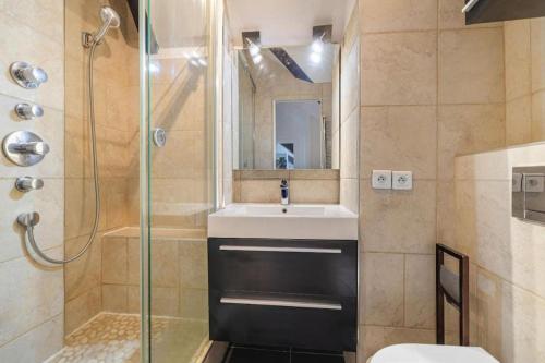 une salle de bain avec un lavabo et une douche dans l'établissement On the rooftops of Paris - Marais, à Paris