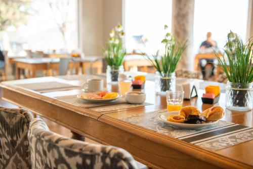 a wooden table with plates of food on it at Hotel Tres Reyes in San Carlos de Bariloche