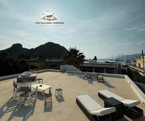 a patio with chairs and tables on a roof at The Vulcano Terrace in Vulcano
