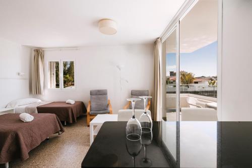 a living room with a table and a balcony at Apartamentos Tarahal in San Agustin