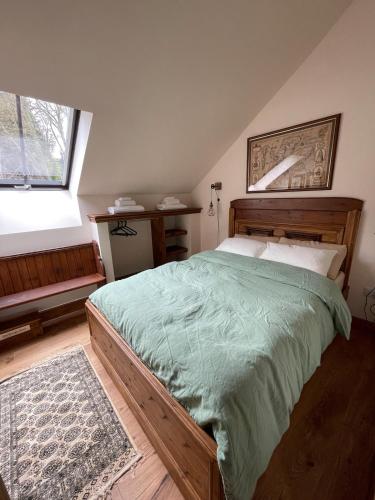 1 dormitorio con cama de madera y edredón verde en Church Brae, en Tomatin