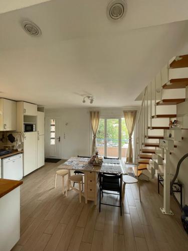 - une cuisine et une salle à manger avec une table et des escaliers dans l'établissement Maison pour vacances en famille, à La Seyne-sur-Mer