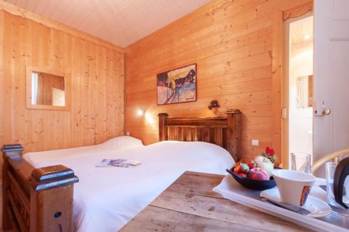 une chambre avec un lit et un bol de fruits sur une table dans l'établissement Hôtel l'Hermitage, à Brides-les-Bains