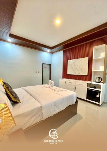 a bedroom with a large bed and a kitchen at Golden Beach Hotel Sekotong in Pulau Gilipoh