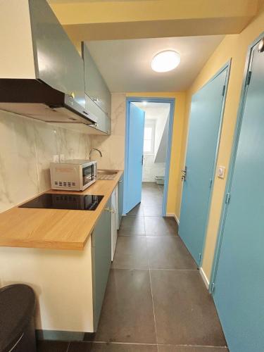 une cuisine avec un évier et un micro-ondes dans l'établissement Hébergement design proche plage, à Trouville-sur-Mer