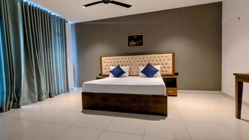 a bedroom with a large bed with blue pillows at Royal Lion Hotel - Kandy Road, Galagadara in Galagedara