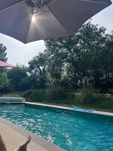 an umbrella sitting next to a swimming pool at Domaine de la Fauvelle in Thuir