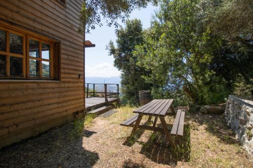a wooden picnic table sitting next to a building at Villa a Croce in Alata