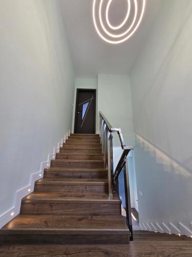 a stairway leading up to a door with a chandelier at Къща Холидей Обзор in Obzor