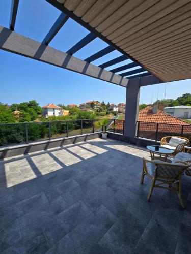 a patio with awning and a table and chairs at Къща Холидей Обзор in Obzor