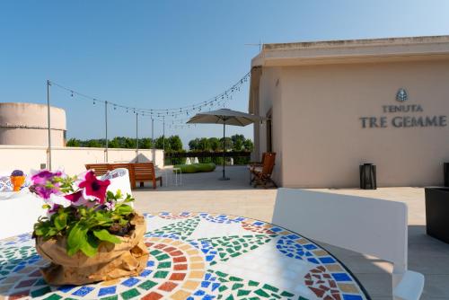 a vase of flowers sitting on a table on a patio at Tenuta Tre Gemme in Cantina- Renascenzia SantIrene in Catignano