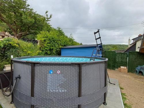 une cage à oiseaux avec une piscine dans une cour dans l'établissement Belle Maison Honfleuraise 10-14 pers piscine, à Fatouville-Grestain
