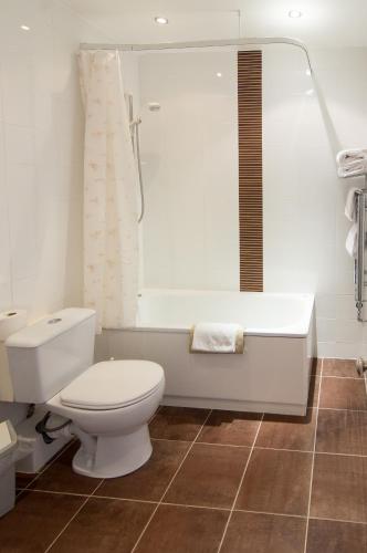 a bathroom with a toilet and a bath tub at South Beach Hotel in Troon