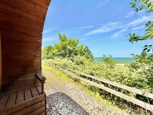 a wooden building with a fence and a view of the ocean at Apart-Hotel Kastanienhof in Dannenfels