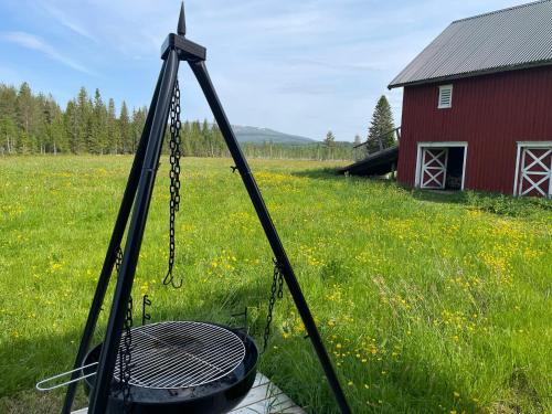 a swing in a field next to a red barn at Idyllisk Småbruk in Landsem