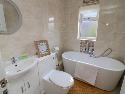 un bagno con vasca, WC e lavandino di James Ville Marina Lodge 10 a Brigg