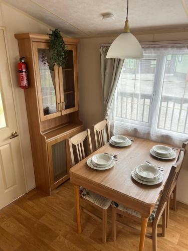 a dining room with a wooden table and chairs at West Lakes Affordable Caravan in Lamplugh