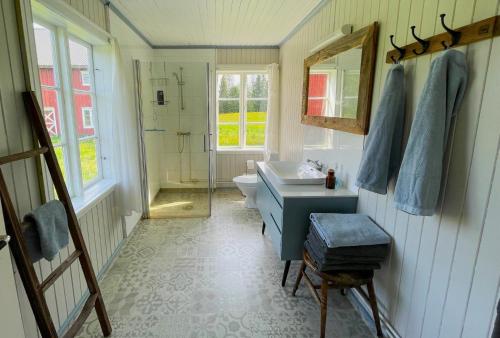 a bathroom with a sink and a toilet and a mirror at Idyllisk Småbruk in Landsem