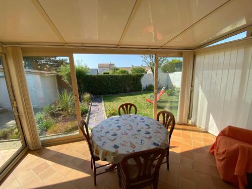 - une table et des chaises sur une terrasse couverte dans l'établissement Le Frangipanier, à Les Sables-dʼOlonne