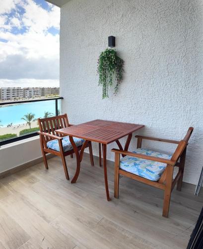 einen Holztisch, eine Bank, einen Tisch und einen Stuhl in der Unterkunft Paradise Apt in Punta Cana in Punta Cana