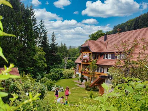 un grupo de personas caminando alrededor de una casa en Hoferpeterhof, en Bad Peterstal-Griesbach
