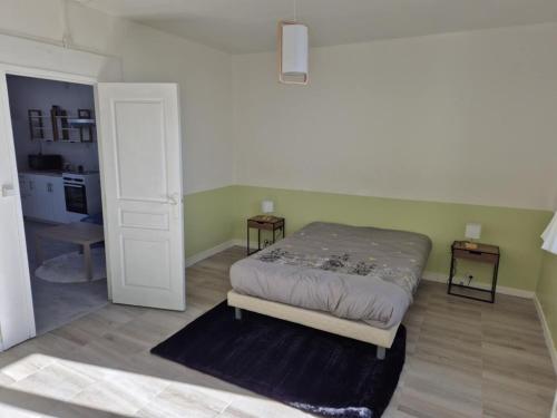 - une chambre avec un lit et deux tables de chevet dans l'établissement Maison de village, à Blet