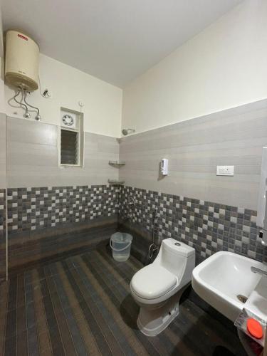 a bathroom with a toilet and a sink at Naidu Nilayam in Secunderabad