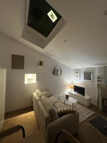 un salon avec un canapé et une télévision dans l'établissement Appartement, à Plouharnel