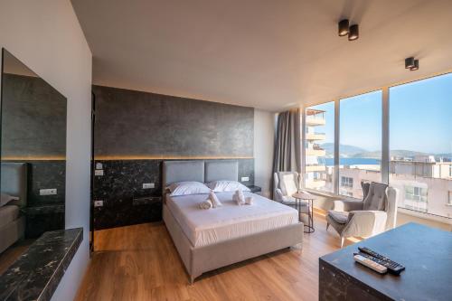 a bedroom with a bed and a large window at Ersa Luxury Rooms in Sarandë