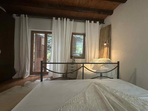 a bedroom with a bed and two windows at Chalet St John in Slatino