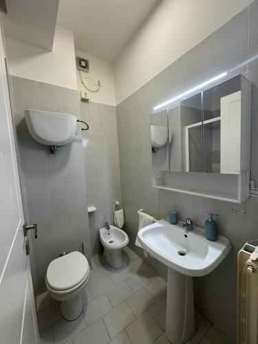 a white bathroom with a toilet and a sink at Nido sul Trasimeno in San Feliciano