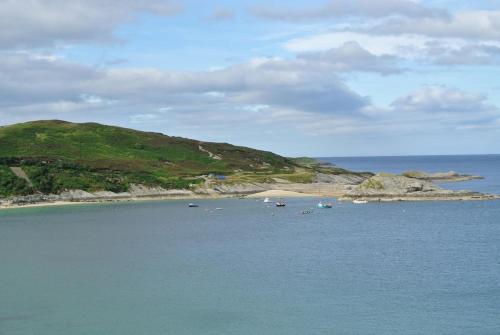 an island in the ocean with boats in the water at The Wee Housie, Talmine in Talmine