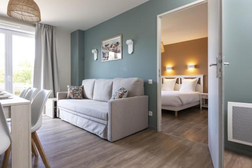 a living room with a couch and a bedroom at Résidence Odalys Les Villas de la Baie in Le Crotoy