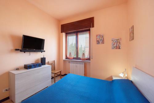a bedroom with a blue bed and a tv at La Casa Della Gioia - Serravalle in Serravalle Scrivia