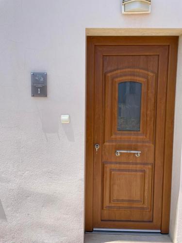 a wooden door in a white wall with a sign at Niki's Paradise View in Taxiarchis