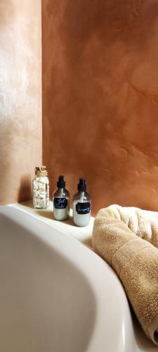 une salle de bain avec deux pots posés sur une baignoire dans l'établissement La cigale blanche, à Fréjus