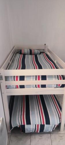 un lit superposé blanc avec des oreillers à rayures colorées dessus dans l'établissement La Dolce Vita, à Marseille