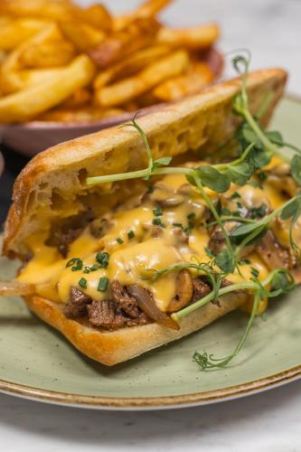 a sandwich with cheese and meat and french fries at The Newgrange Hotel in Navan