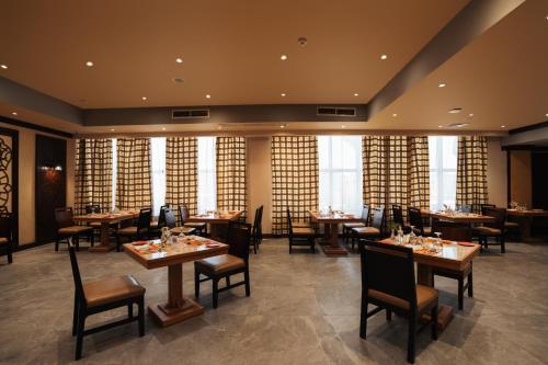 a restaurant with tables and chairs and windows at Riviera Aqua Park Resort in Hurghada