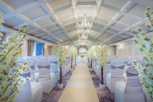 a row of chairs in a banquet hall with trees at The Newgrange Hotel in Navan