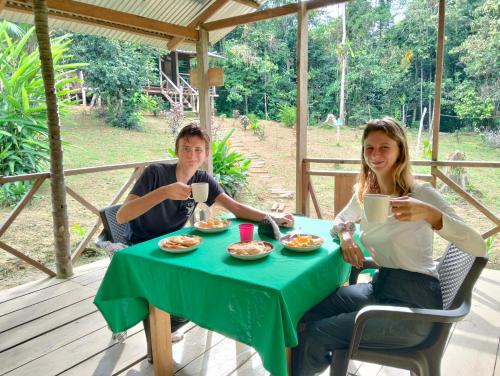 two people sitting at a table with food at Cabañas eco lógicas mu'ü in Loreto Mocagua
