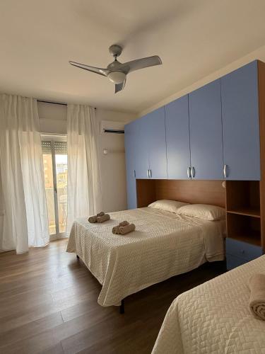 a bedroom with two beds and a ceiling fan at Casa Ammàri in Marsala