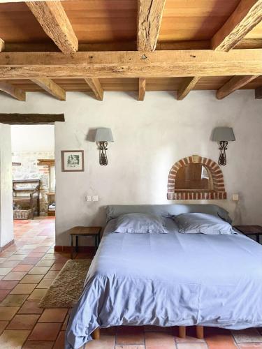 ein Schlafzimmer mit einem Bett mit Holzdecke in der Unterkunft Maison avec piscine & tennis partagés - proche Châteaux de la Loire - 1h30 de Paris in Combreux