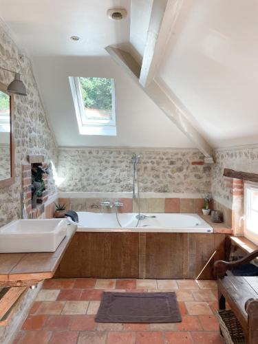 ein großes Badezimmer mit Badewanne und Waschbecken in der Unterkunft Maison avec piscine & tennis partagés - proche Châteaux de la Loire - 1h30 de Paris in Combreux