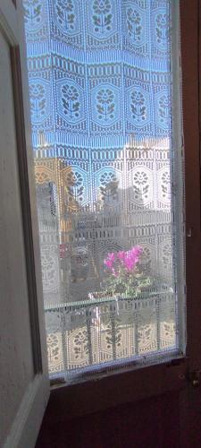 a window with a view of a balcony with pink flowers at Dimora Maltese in Morciano di Leuca