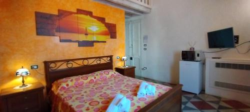 a bedroom with a bed and a painting on the wall at Dimora Maltese in Morciano di Leuca