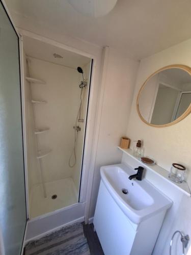 une salle de bain blanche avec une douche et un lavabo dans l'établissement Le rivage, à Vias