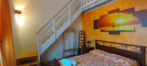 a bedroom with a bed and a staircase with a painting at Dimora Maltese in Morciano di Leuca
