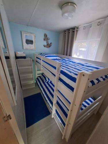 - une chambre avec des lits superposés blancs et bleus dans l'établissement Le rivage, à Vias