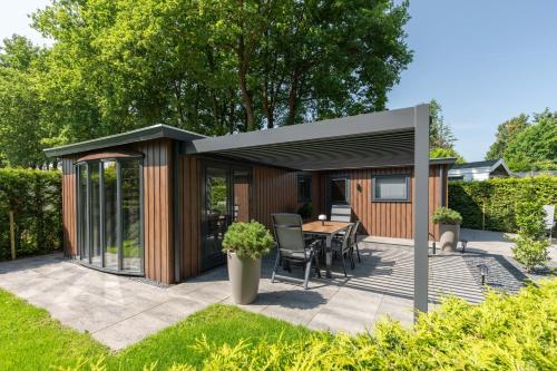 a garden pavilion with a table and chairs at Bosrijk Austerpark chalet 29 in Putten